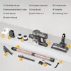 A collection of cordless vacuum cleaner parts and accessories laid out on a light gray surface, with labels pointing to each item. Náhled obrázku produktu