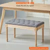 A gray upholstered bench with wooden legs is placed under a wooden table. Podgląd zdjęcia produktu