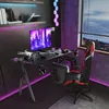 A gaming desk setup with a computer, chair, and accessories, illuminated by LED lights. Voir les images du produit