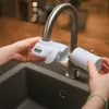 Hands attaching a water filter to a faucet over a sink. Náhled obrázku produktu