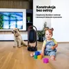 A dog and a baby are sitting on a wooden floor next to a heater, with building elements in the background. Podgląd zdjęcia produktu