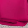 A close-up of fuchsia fabric, likely a curtain, folded and resting on a light wooden surface. Produktbild-Vorschau