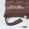 Close-up of a brown seat cushion with adjustable straps and buttons. Anteprima dell’immagine prodotto