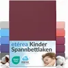 A product image showcasing a burgundy fitted sheet with multiple other colored fitted sheets stacked behind it, along with cotton bolls and a sleeping child. Náhľad obrázku produktu