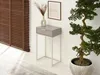 A narrow console table with a drawer, a vase with dried flowers, and a framed picture on a wall, next to a large potted plant. A wooden blind is visible on the left. Produktbild-Vorschau