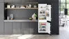 A modern kitchen scene with a built-in refrigerator open, displaying its contents, alongside cabinetry and shelves. Voir les images du produit