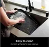 A person is cleaning a grill grate in a sink. Voir les images du produit