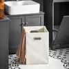 A bathroom scene with a sink, vanity, and laundry hamper. Anteprima dell’immagine prodotto