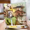 A 3D wooden model of a traditional Japanese scene with cherry blossoms and a building, held by two hands. Náhled obrázku produktu