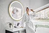 A woman in a bathrobe and towel is posing in a modern bathroom. Voir les images du produit