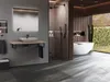 A modern bathroom with a freestanding bathtub, a walk-in shower, and a vanity with a vessel sink, overlooking a garden. Produktbild-Vorschau