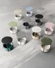 A collection of small, round side tables with storage baskets, arranged on a concrete floor. Náhled obrázku produktu