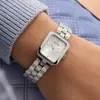 A close-up shot of a woman's wrist wearing a silver Guess watch. Produktbild-Vorschau
