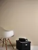 A white chair and two black storage boxes with books on top, set against a plain beige wall. Produktbild-Vorschau