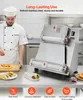 A chef is shown next to a commercial dough roller with various food items laid out on a stainless steel counter. Podgląd zdjęcia produktu