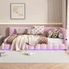 A pink upholstered daybed with several pillows and a blanket, set in a bedroom with a rug and a framed picture on the wall. Produktbild-Vorschau