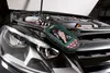 A diagnostic tool is placed on the hood of a car with the hood open, showing the engine. Produktbild-Vorschau