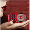 A close-up of a person's hand holding a red retro radio, with their lips visible in the background. Produktbild-Vorschau