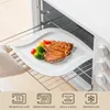 A white plate with a steak and vegetables is placed on an oven rack inside an open oven. Náhled obrázku produktu