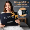A woman is holding a gift-wrapped box containing a weighted blanket. Produktbild-Vorschau