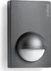A dark gray motion sensor with a white sensor lens is shown against a light gray background. Podgląd zdjęcia produktu