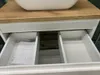 A partially opened bathroom vanity drawer showing a manual. Anteprima dell’immagine prodotto
