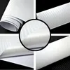 A collage of four close-up images showing different angles and details of a roll of white carbon fiber textured adhesive film. Produktbild-Vorschau
