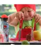 A child is holding two Opinel knives, one green and one red, at a table with food and a water bottle. Podgląd zdjęcia produktu