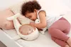 A young child sleeping on a bed with a whale-shaped night light and a small stuffed animal. Anteprima dell’immagine prodotto