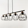A black linear pendant light fixture with five geometric metal shades and exposed bulbs, suspended against a white background. Produktbild-Vorschau