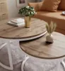 A living room scene with a nesting coffee table set, featuring a plant in a gold vase and dried grass in a small vase. Náhľad obrázku produktu