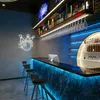 A modern bar area with a counter, stools, and decorative lighting. Anteprima dell’immagine prodotto