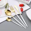 A set of gold and white cutlery laid out on a magazine or brochure. Voir les images du produit