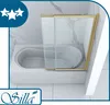 A bathtub with a glass shower enclosure with gold trim. Produktbild-Vorschau
