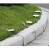 Solar pathway lights embedded in a grassy area next to a sidewalk. Anteprima dell’immagine prodotto