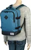 A person wearing a gray sweater and blue jeans is wearing a teal backpack. Produktbild-Vorschau