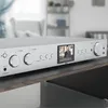 A silver Hama HiFi-Tuner DIT2105SBTX is displayed on a dark wooden surface in a well-lit room. Anteprima dell’immagine prodotto