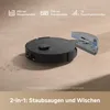 A black robot vacuum cleaner with a detached water tank on a light brown surface. Produktbild-Vorschau