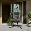 An outdoor patio with a hanging egg chair. Produktbild-Vorschau