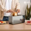 A person is placing toast into a Balter toaster on a wooden countertop, with breakfast items like eggs and tomatoes visible. Produktbild-Vorschau