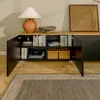 A modern sideboard or TV cabinet with open doors, displaying books, decorative items, and woven baskets. Voir les images du produit