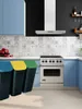 A kitchen scene with blue cabinets, a stove, and three trash cans in the foreground. Náhľad obrázku produktu