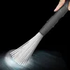 A hand holding a vacuum cleaner attachment with fine bristles. Produktbild-Vorschau