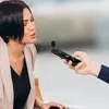 A woman is being interviewed with a microphone attached to a smartphone. Podgląd zdjęcia produktu