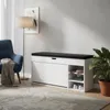 A shoe cabinet with a seat in a room with a chair, lamp, and plant. Produktbild-Vorschau