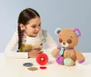 A young girl is playing with a teddy bear and sewing accessories. Podgląd zdjęcia produktu