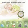 A child sleeping next to a teddy bear with a small alarm clock in the foreground. Below are graphics illustrating different decibel levels with corresponding scenarios. Produktbild-Vorschau
