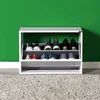 A shoe cabinet filled with shoes against a green wall. Podgląd zdjęcia produktu