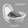 A collapsible laundry basket filled with clothes, shown with its lid open next to it. Produktbild-Vorschau