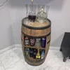A wooden barrel-shaped bar cabinet filled with bottles of alcohol and glasses. Náhled obrázku produktu